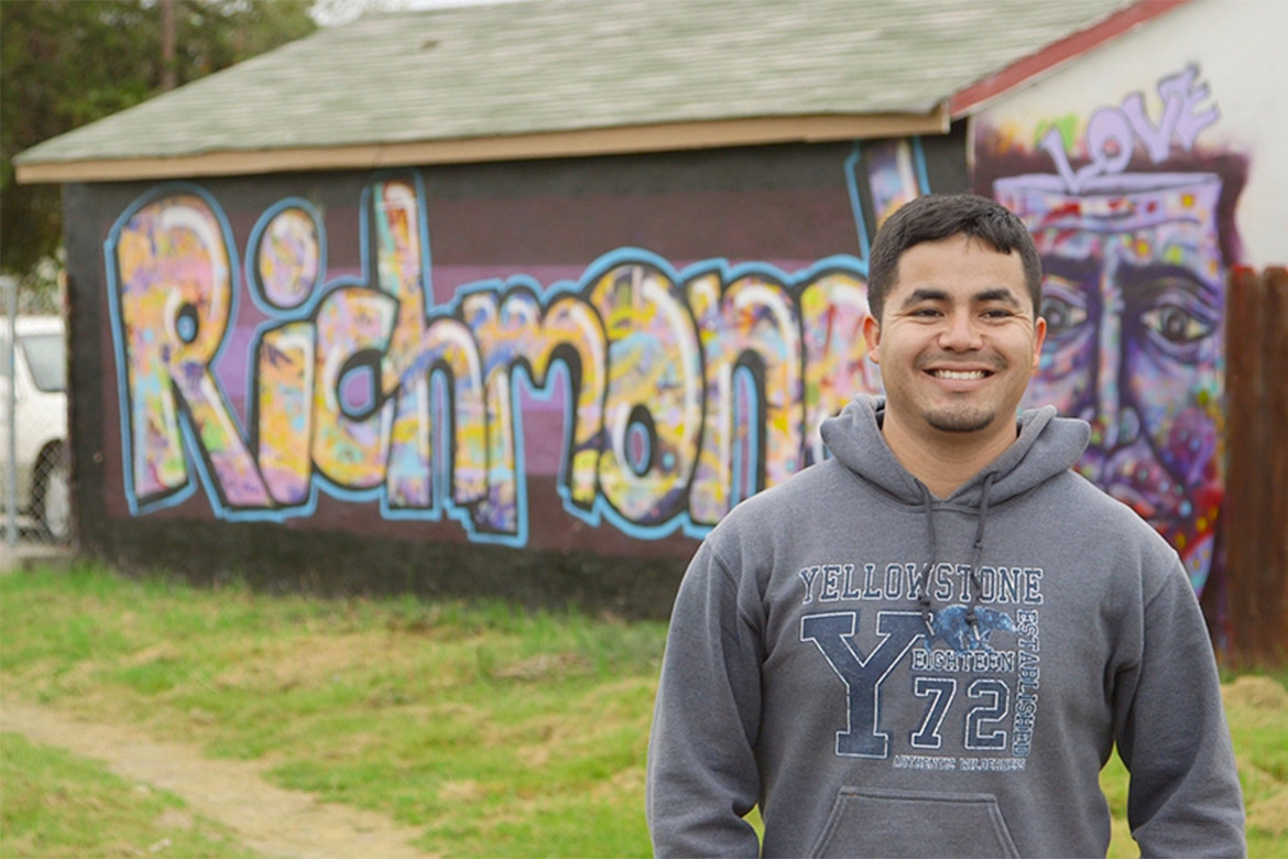 Javier Ochoa Reyes, Groundwork Richmond project coordinator, in front of Richmond Greenway mural