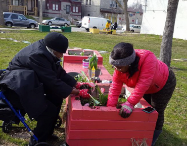 Women planting flower bed in Milwaukee's 2nd Street Pocket Park, designed as a safe area for children and families