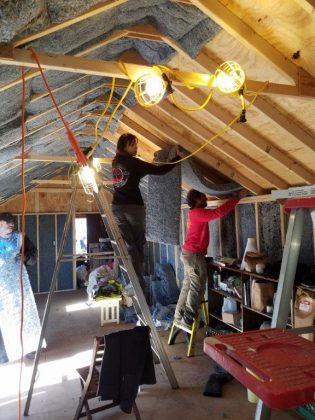 Installing denim insulation in learning center